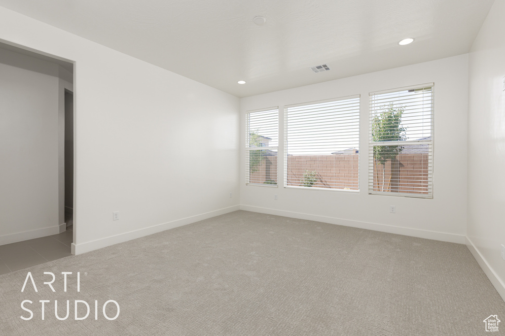 Spare room featuring light colored carpet, recessed lighting, and baseboards