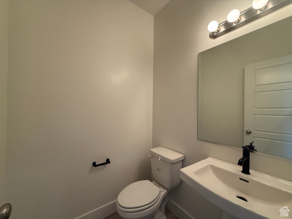 Bathroom with a sink, toilet, and baseboards