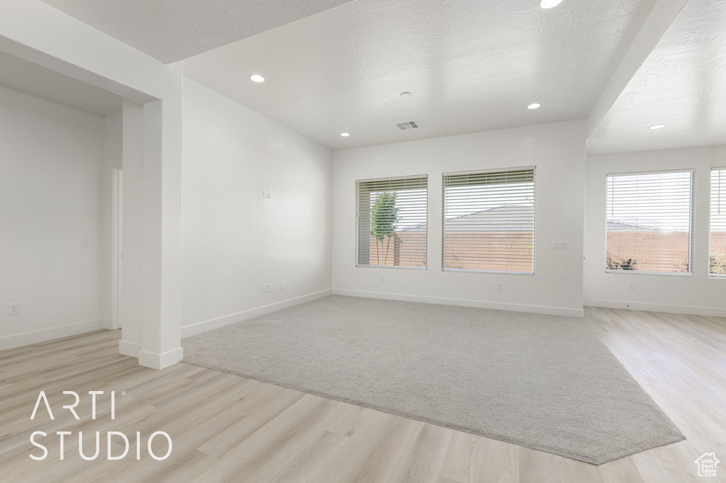 Unfurnished living room featuring light wood-type flooring, recessed lighting, and baseboards