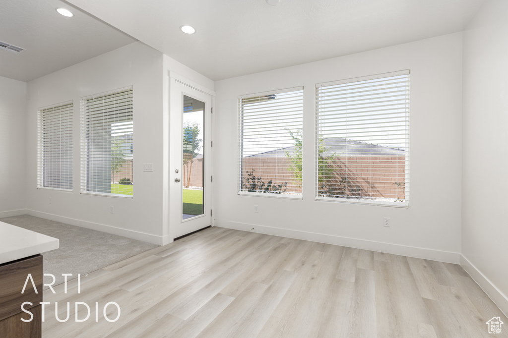Unfurnished room with plenty of natural light, light wood finished floors, baseboards, and recessed lighting