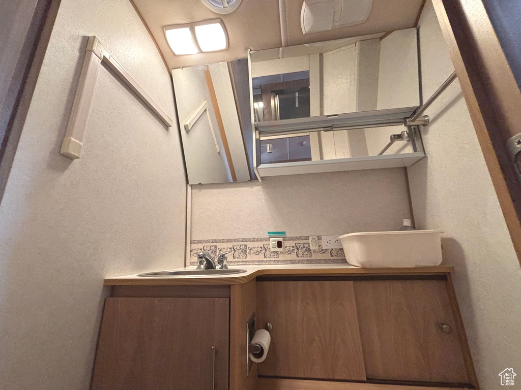 Bathroom featuring vanity and a textured wall