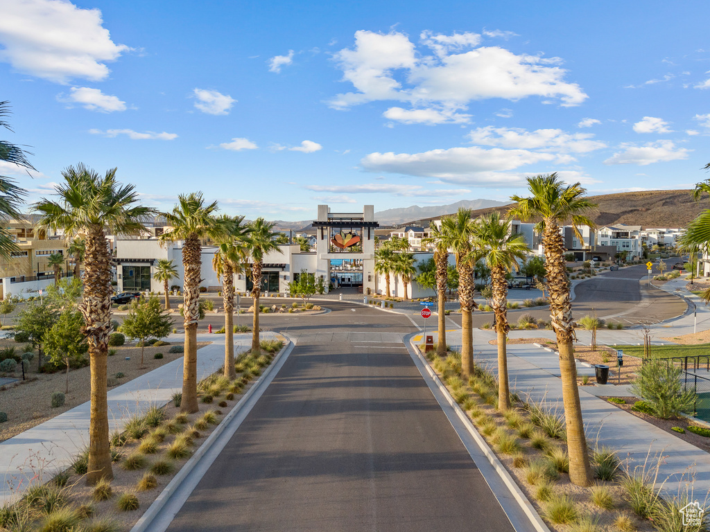 View of asphalt road featuring traffic signs, sidewalks, curbs, and a mountain view