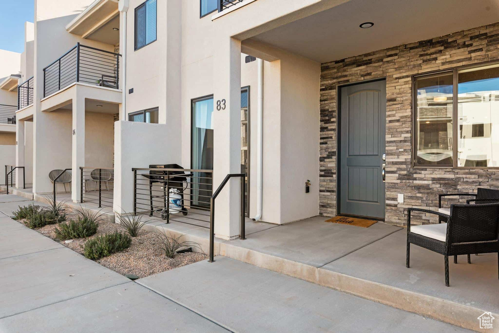 Entrance to property featuring stone siding and stucco siding