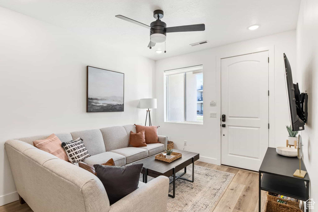 Living area with light wood-style flooring, recessed lighting, ceiling fan, and baseboards