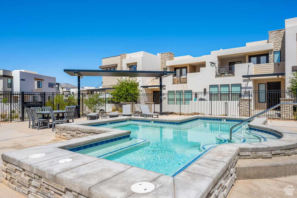 Community pool featuring fence, a residential view, and a patio area