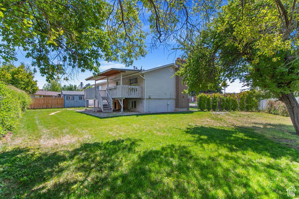 Rear view of house featuring stairs, a deck, a storage shed, and an outdoor structure