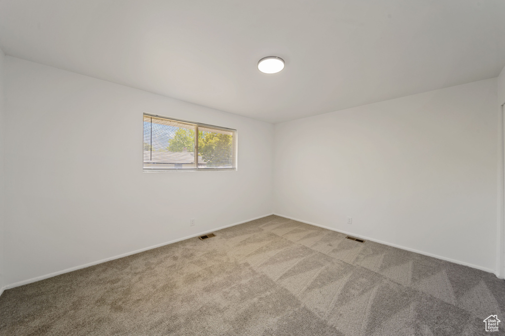 Spare room with light carpet and baseboards