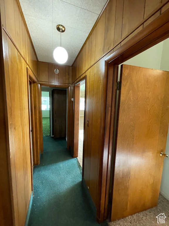 Hall with carpet flooring and wooden walls