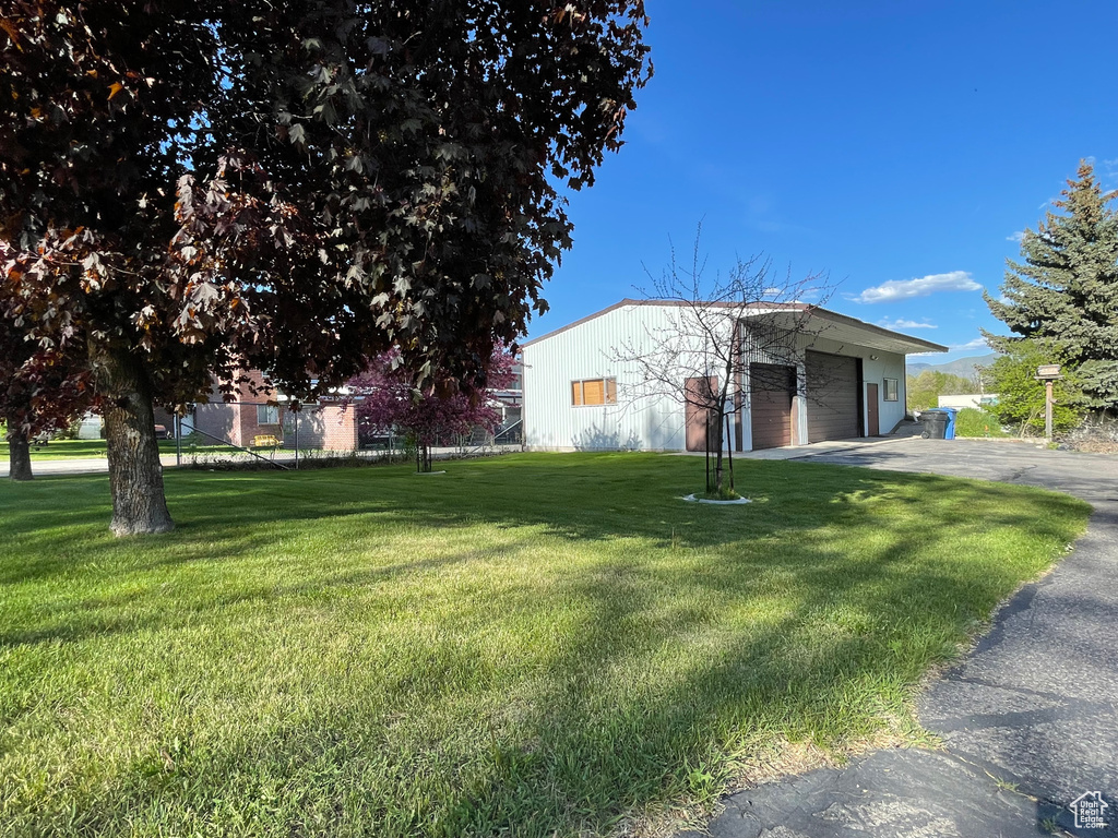 View of front of home featuring a detached garage and a front yard