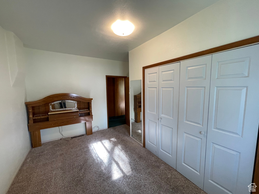 Unfurnished bedroom with carpet and a closet