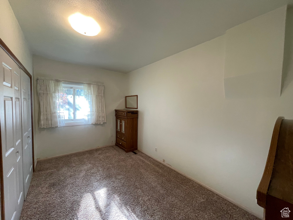 Unfurnished bedroom featuring carpet and a closet