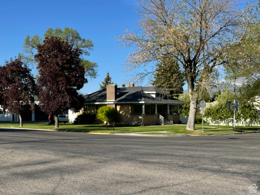View of home's exterior with a chimney and a lawn