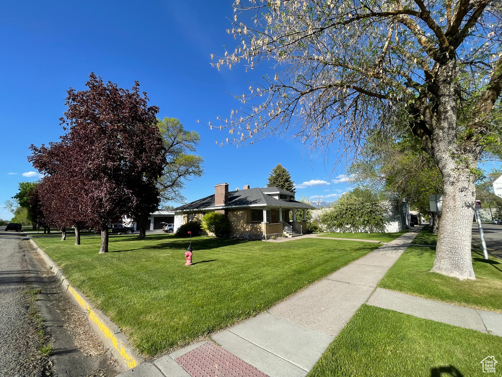 View of front facade with a front yard and a chimney