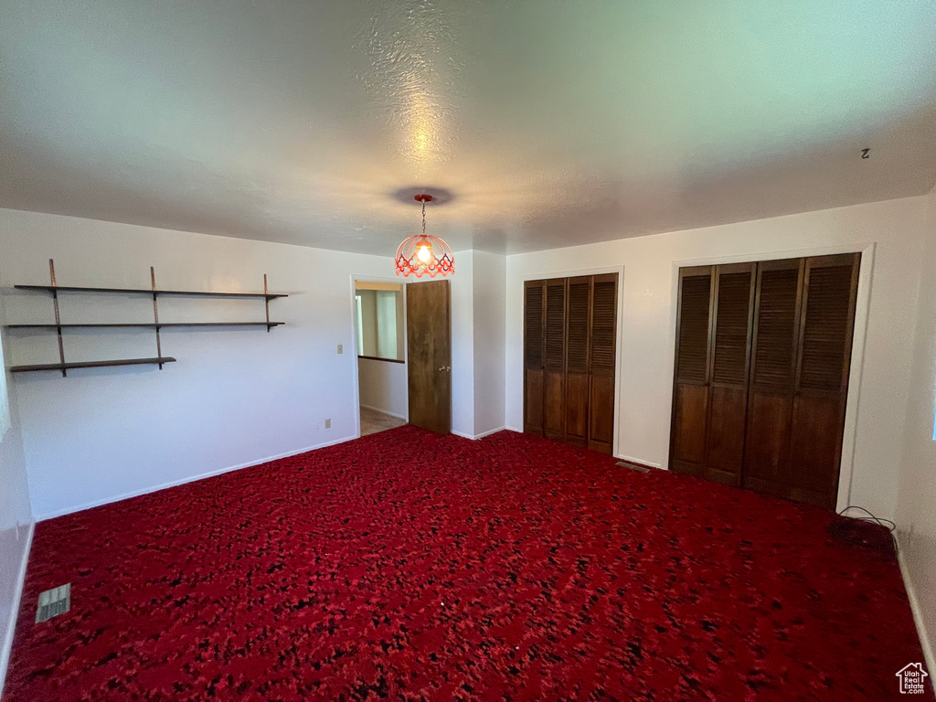 Unfurnished bedroom featuring multiple closets, carpet, and baseboards
