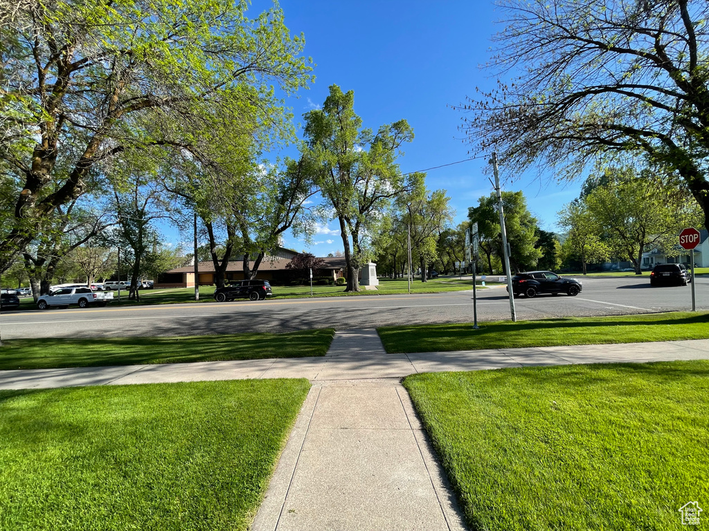 View of asphalt street featuring sidewalks and traffic signs