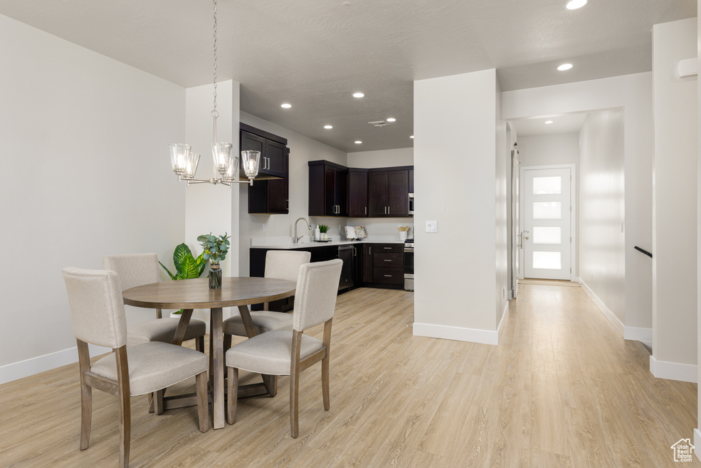 Dining area featuring baseboards, light wood-style floors, a chandelier, and recessed lighting