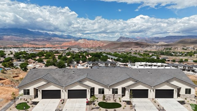 View of front of home with a mountain view, concrete driveway, and a garage