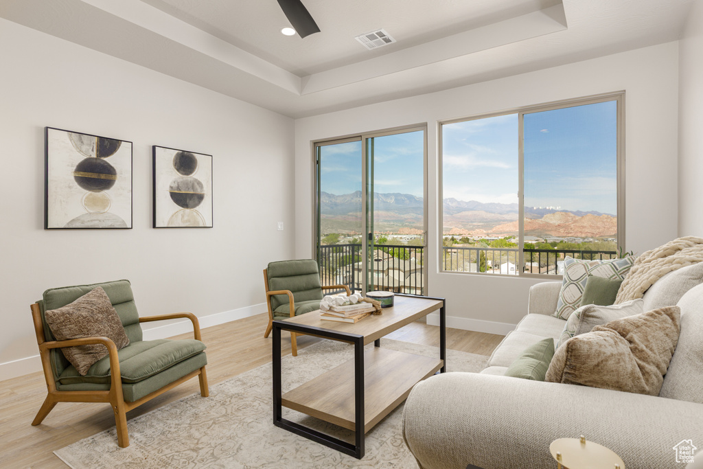 Living room with a raised ceiling, a mountain view, baseboards, healthy amount of natural light, and recessed lighting