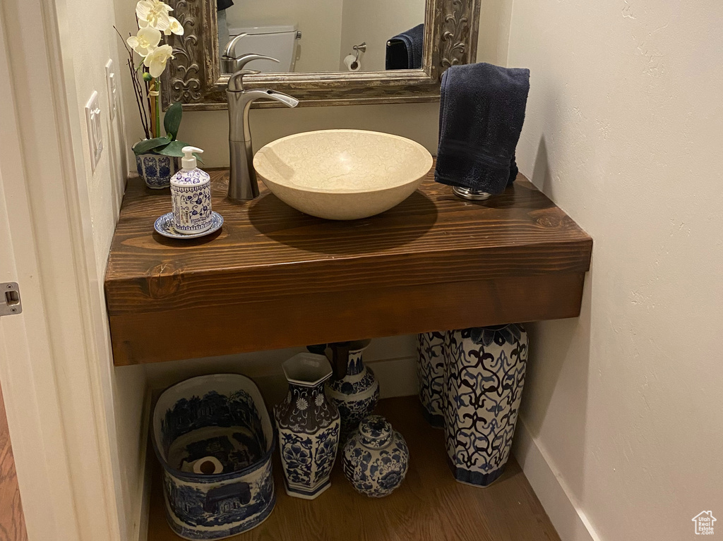 Bathroom with a sink, wood finished floors, and baseboards