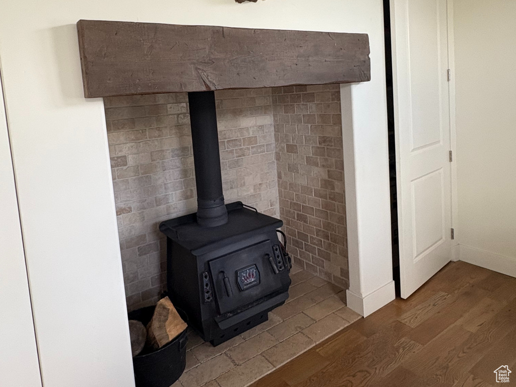 Detailed view of wood finished floors, a wood stove, and baseboards