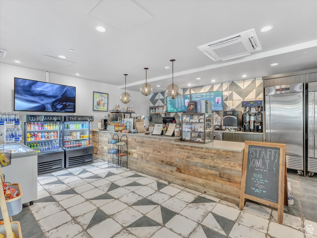 Bar with built in fridge and recessed lighting