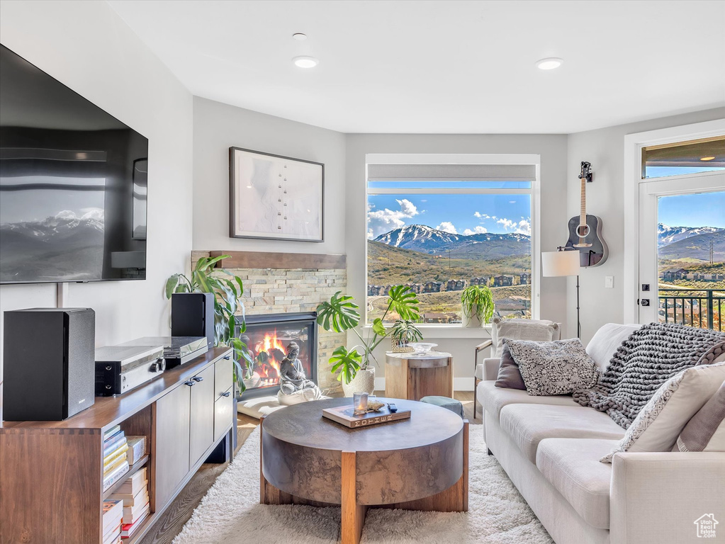 Living area with a mountain view, wood finished floors, a fireplace, and recessed lighting
