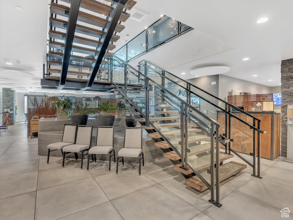 Stairs featuring a towering ceiling and concrete flooring