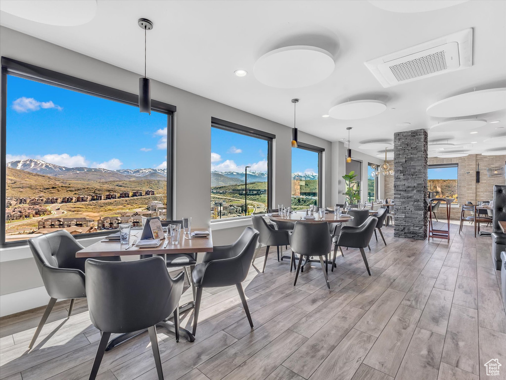 Dining space with wood finished floors, a mountain view, recessed lighting, healthy amount of natural light, and decorative columns