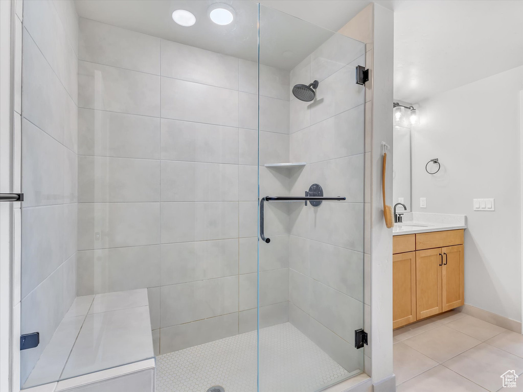 Full bathroom featuring a stall shower, tile patterned flooring, vanity, and baseboards