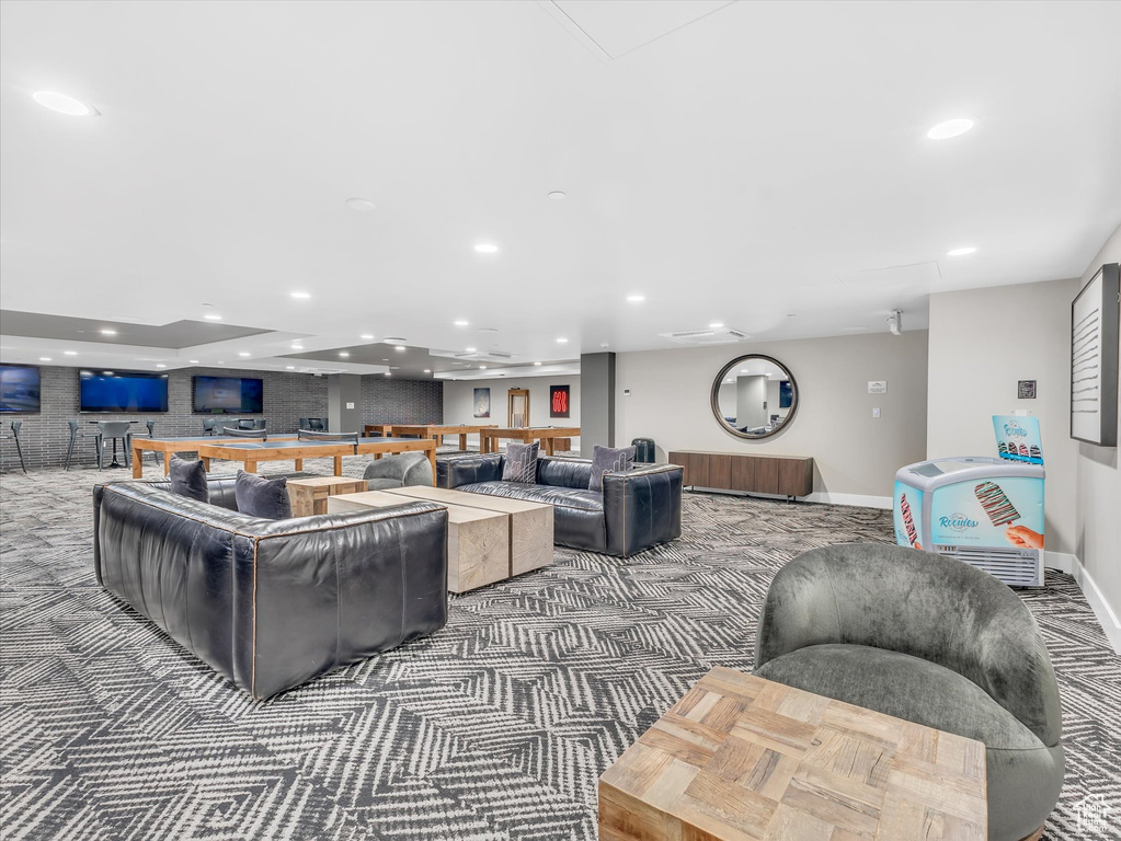 Carpeted living area with recessed lighting and baseboards
