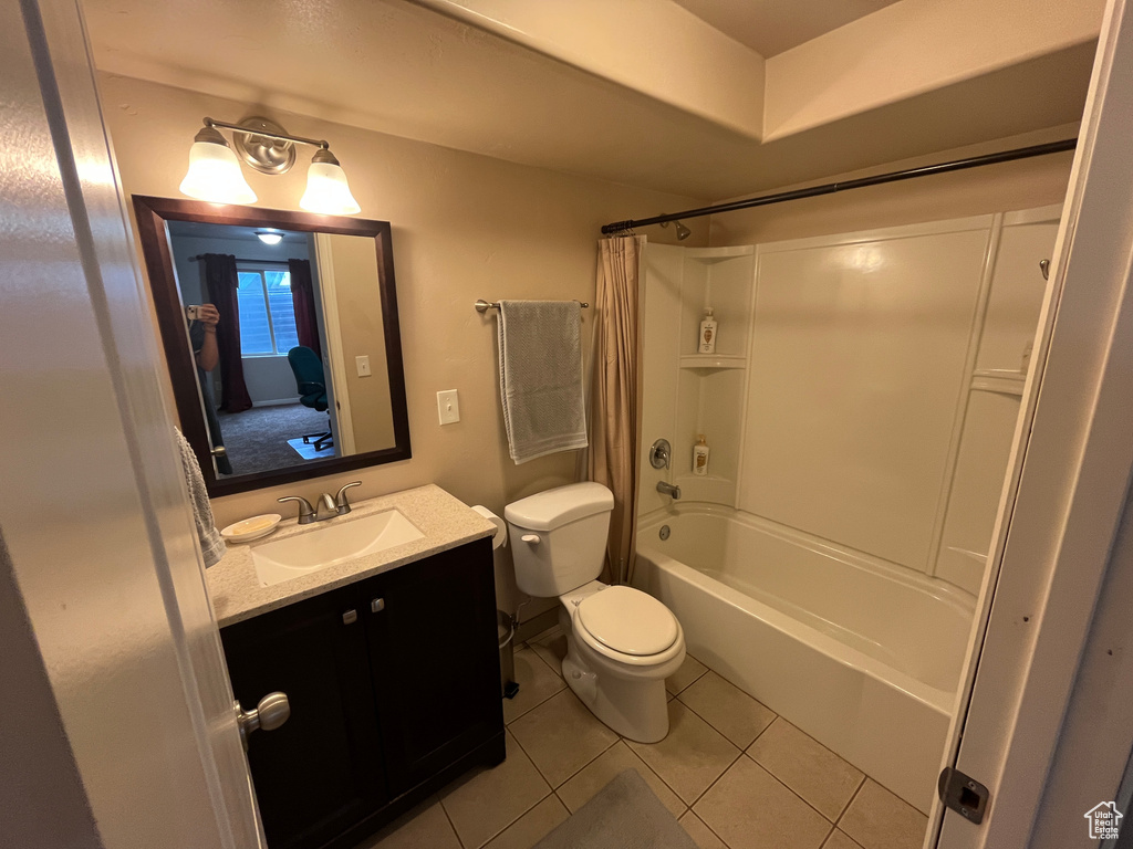 Bathroom featuring tile patterned flooring, vanity, toilet, and shower / tub combo with curtain