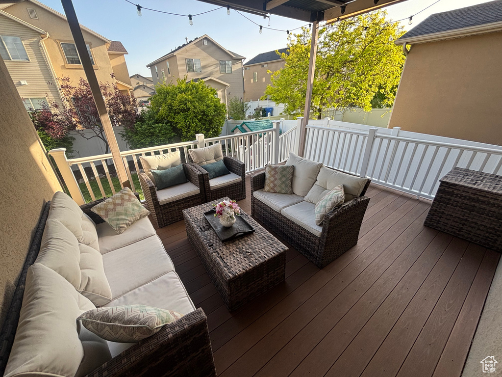 Wooden terrace with an outdoor hangout area, a residential view, and a fenced backyard