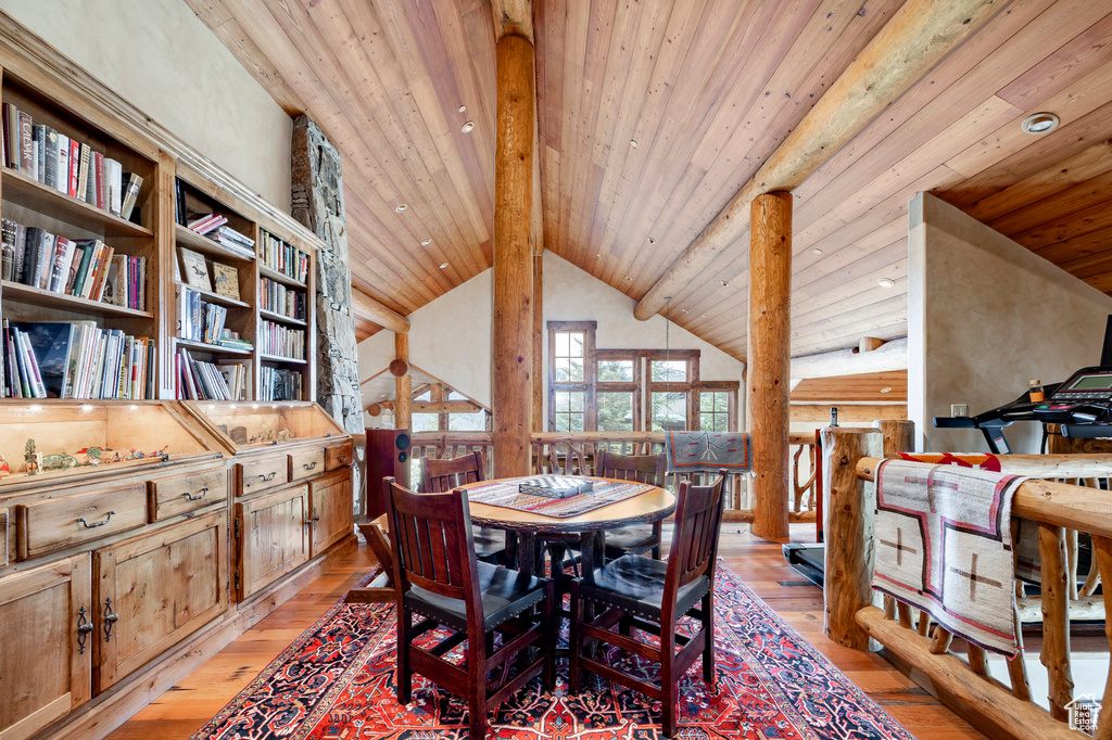 Dining area featuring light wood-style floors, wooden ceiling, beam ceiling, and high vaulted ceiling