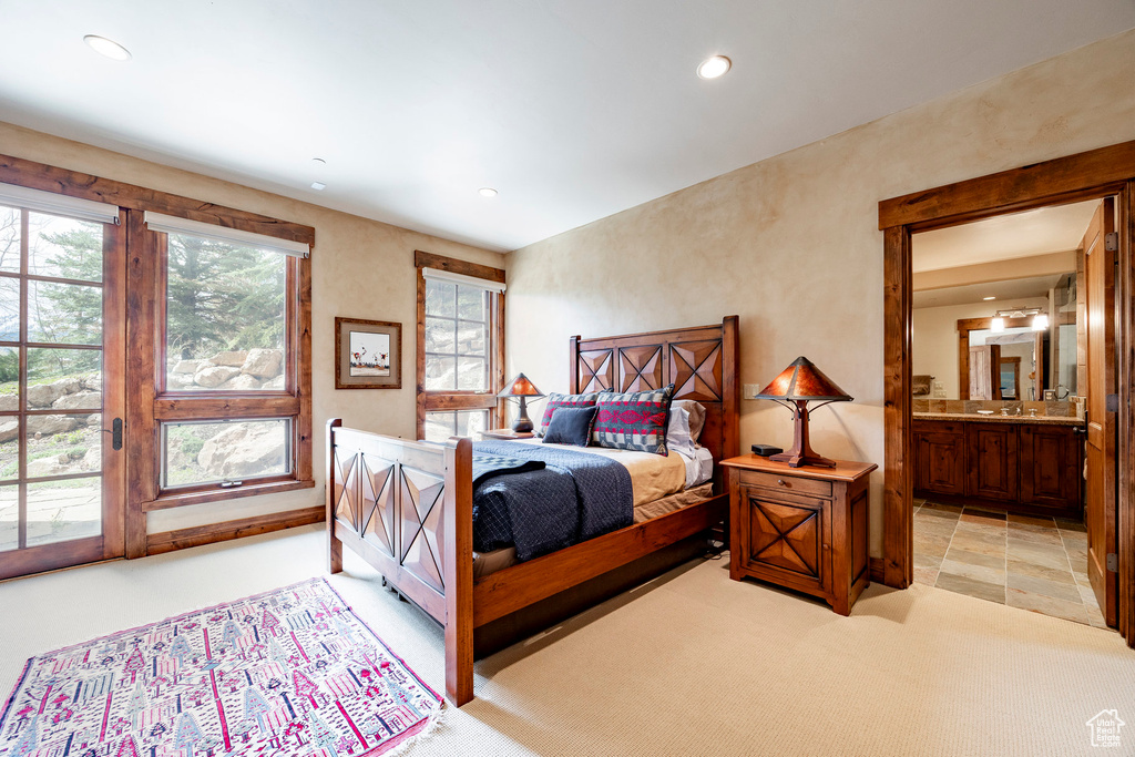 Bedroom with recessed lighting, ensuite bathroom, light carpet, and access to outside