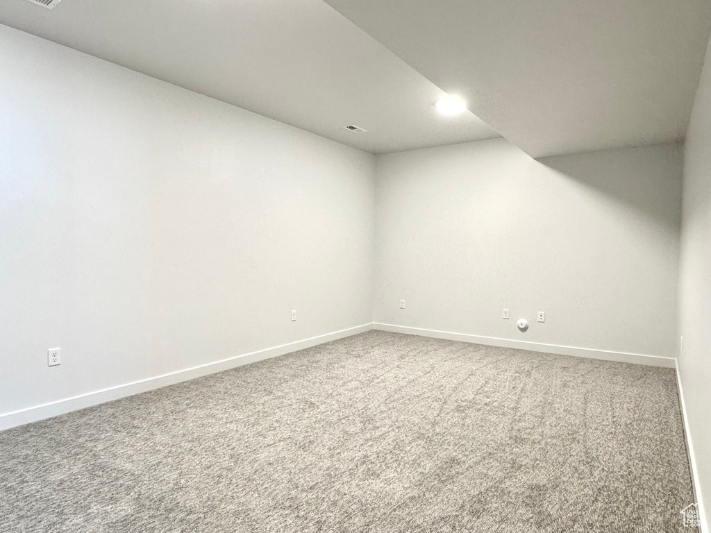 Finished basement with baseboards and carpet