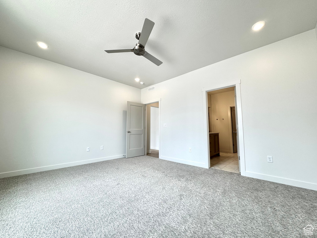 Unfurnished bedroom with baseboards, light carpet, recessed lighting, ensuite bathroom, and a ceiling fan
