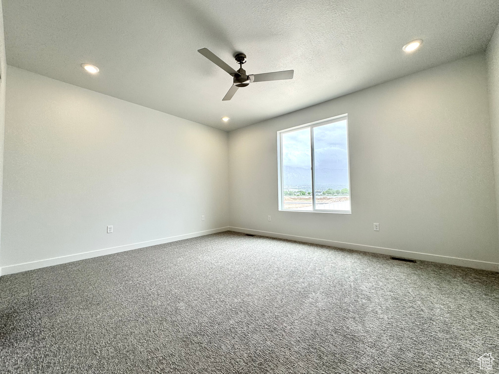 Carpeted spare room featuring ceiling fan, recessed lighting, and baseboards