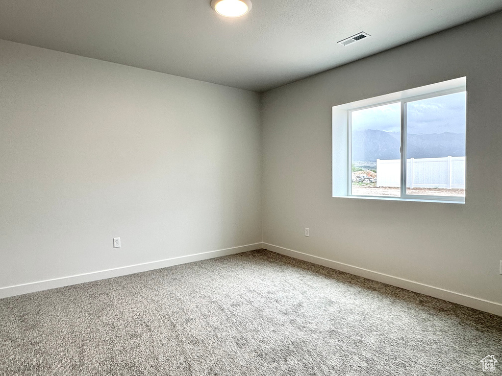 Spare room featuring baseboards and carpet floors