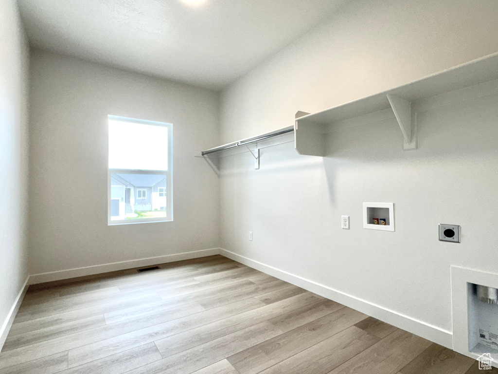 Washroom featuring washer hookup, light wood-style flooring, hookup for an electric dryer, and baseboards
