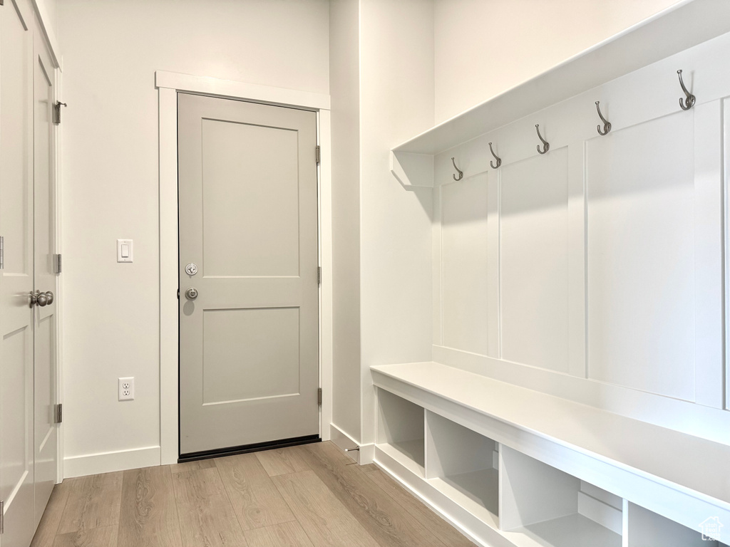 Mudroom with light wood finished floors and baseboards