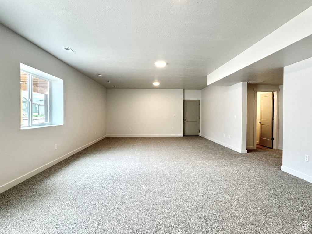 Below grade area with baseboards, carpet flooring, recessed lighting, and a textured ceiling