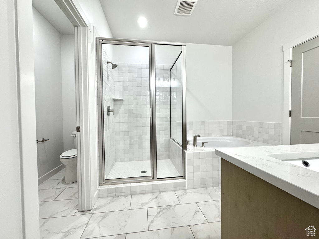 Bathroom featuring marble look tiles, a stall shower, toilet, and recessed lighting