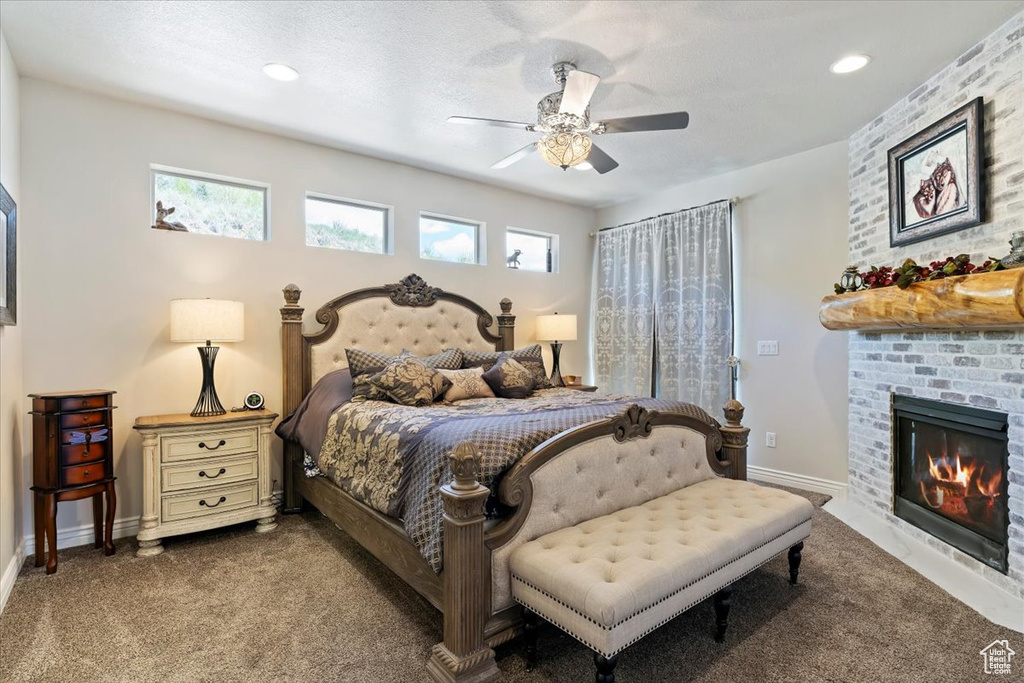 Carpeted bedroom with multiple windows, a brick fireplace, baseboards, and recessed lighting