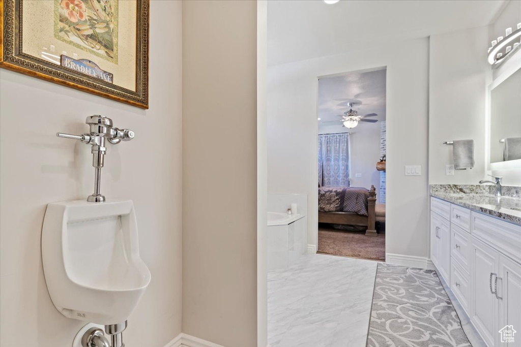 Full bath with ensuite bath, marble finish flooring, baseboards, ceiling fan, and vanity