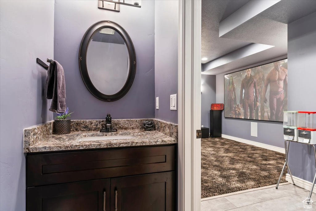 Bathroom with vanity, baseboards, and tile patterned floors