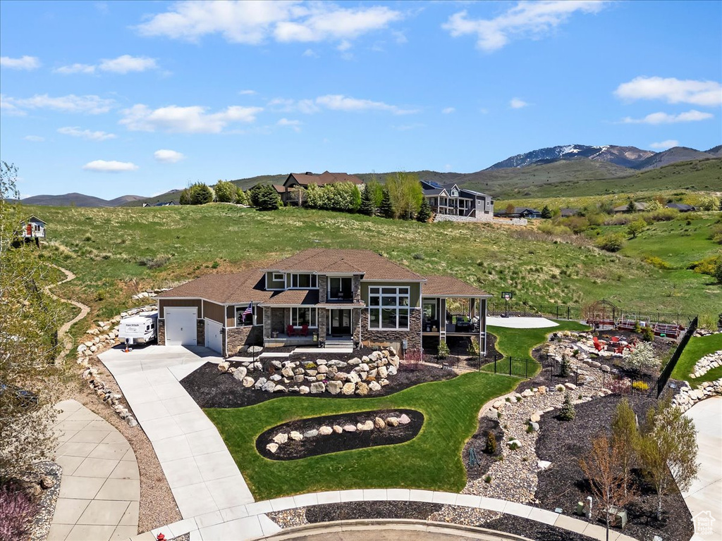 Aerial view of property and surrounding area featuring a mountainous background