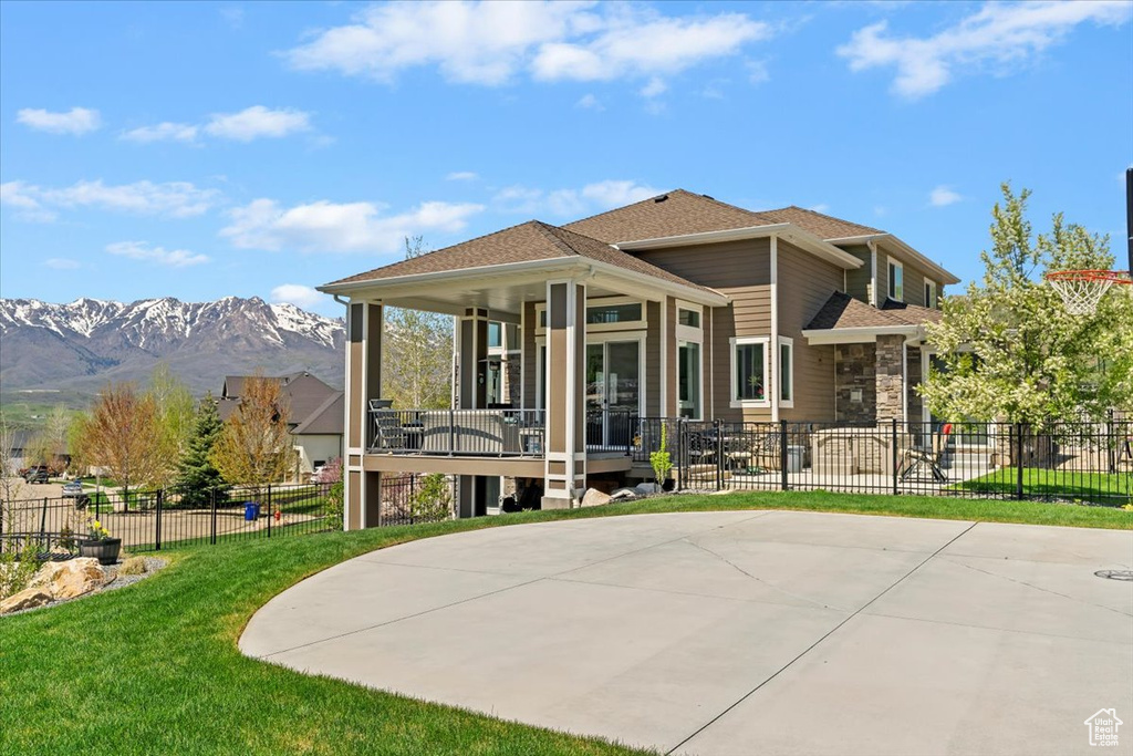 Back of house featuring a mountain view and stone siding