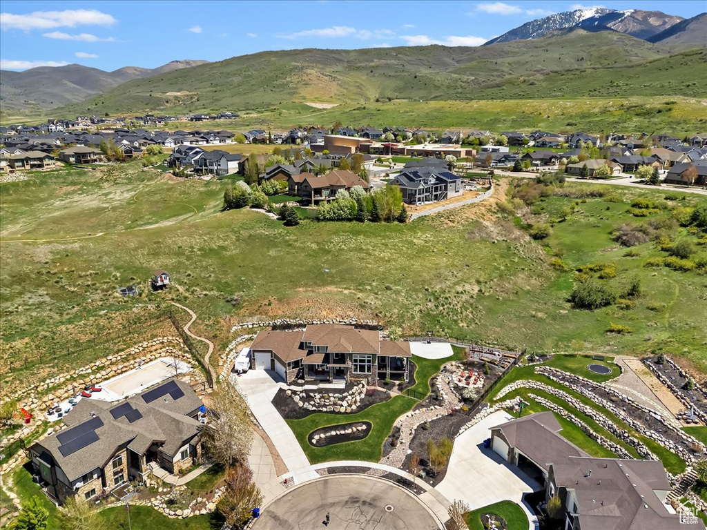 Aerial view of property and surrounding area with nearby suburban area and a mountain backdrop