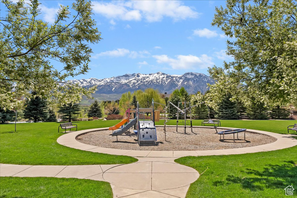 Communal playground with a mountain view and a lawn