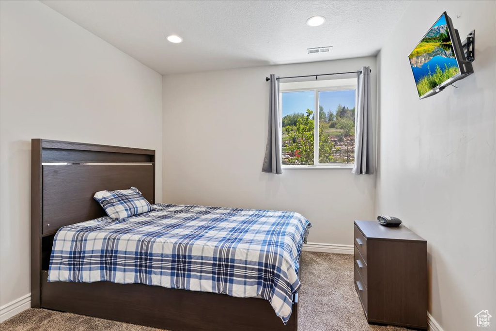 Carpeted bedroom with baseboards, a textured ceiling, and recessed lighting